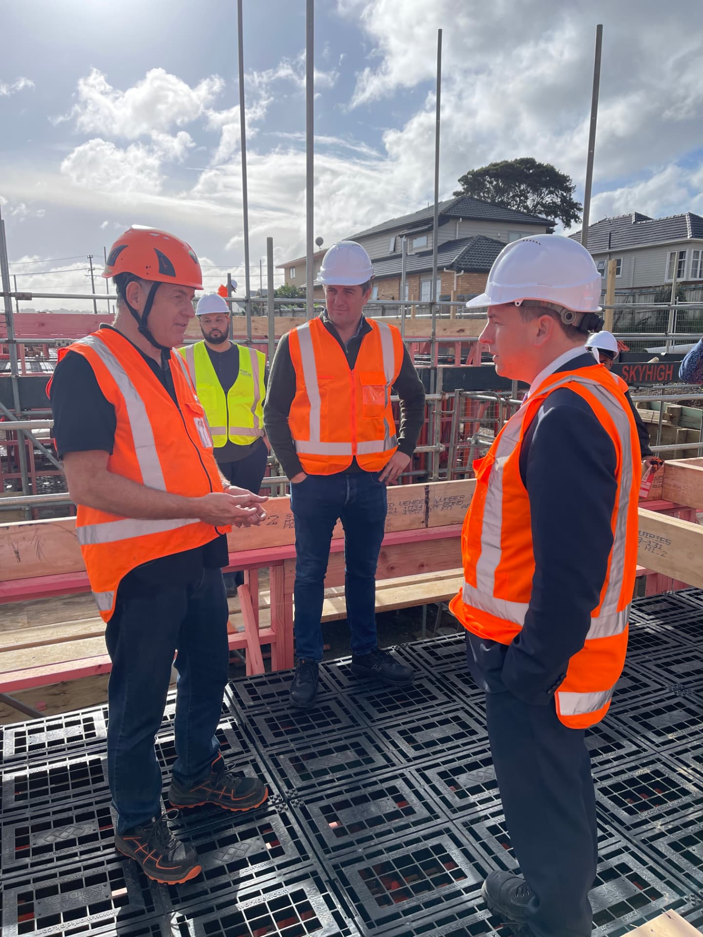 Workdek team talking with visitors in hi-vis vests while standing on a Workdek platform