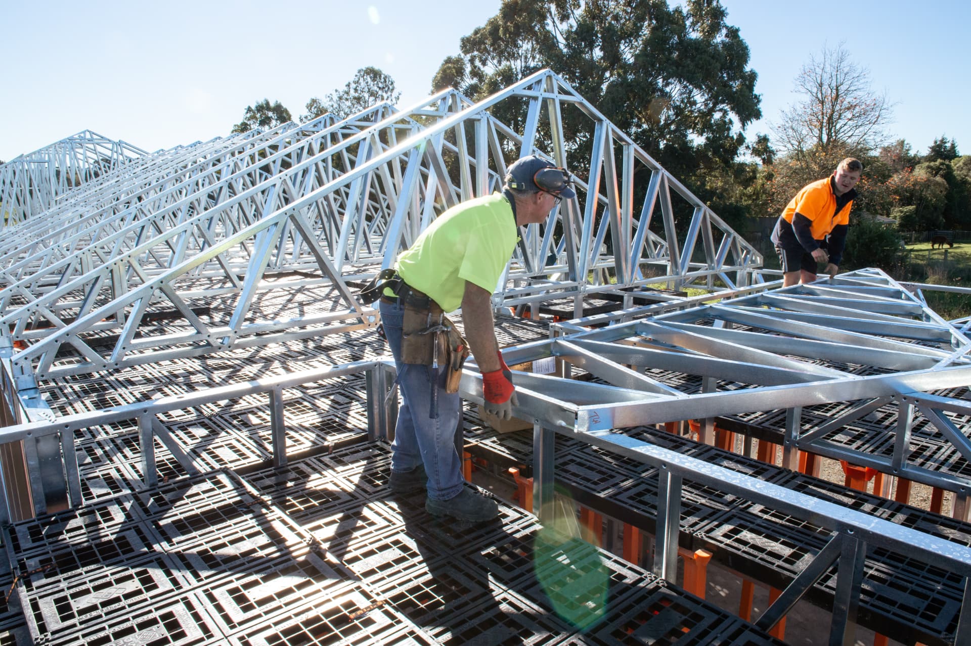 Builders working from a Workdek platform under a timber truss roof