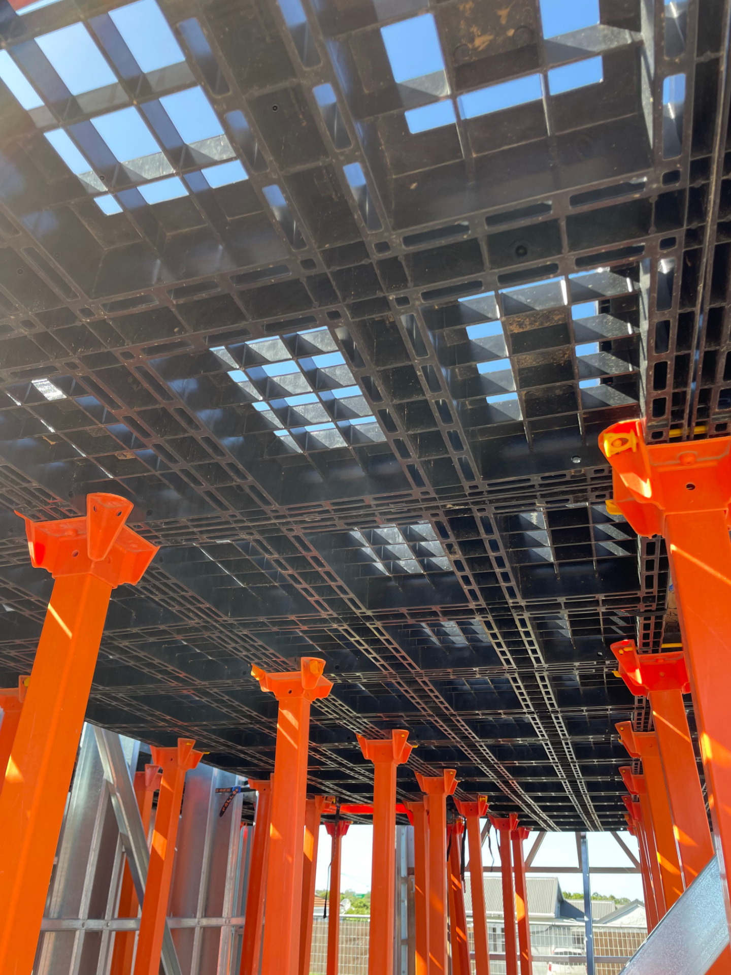 View from below of a Workdek deck supported by orange legs and cradles